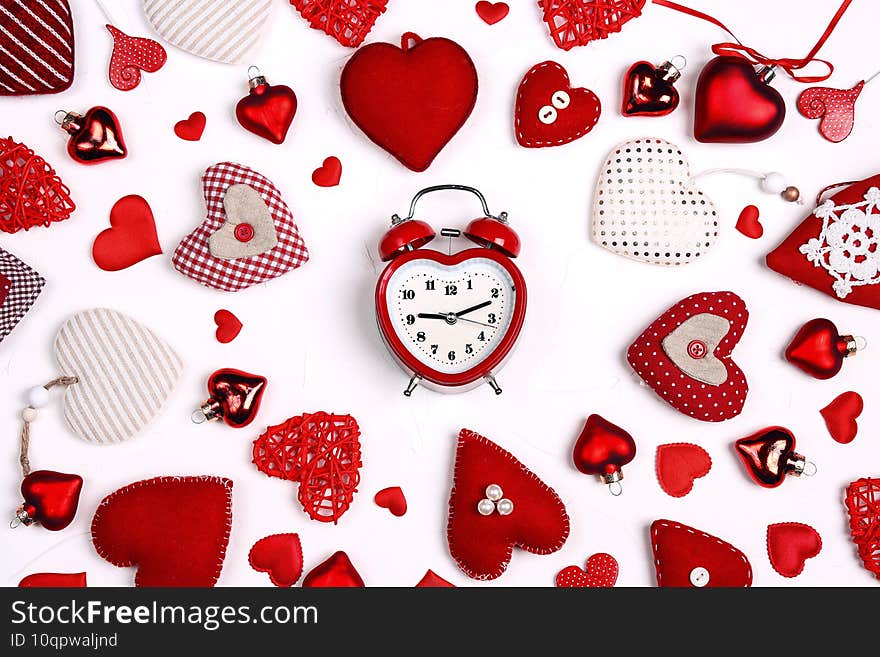 Valentine`s day composition with alarm clock and many different hearts on white background. Flat lay, top view. Time for love and greetings