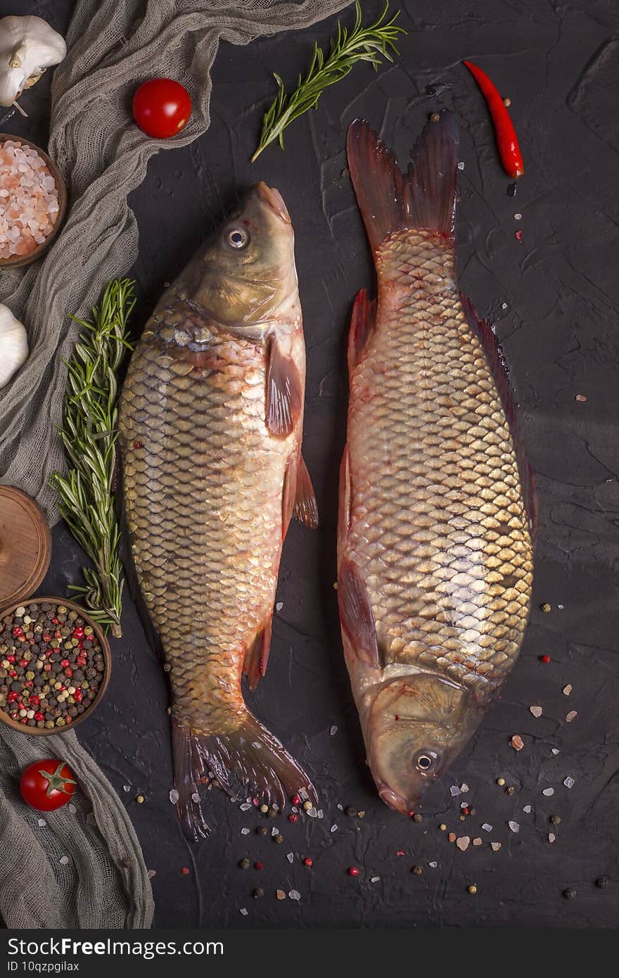 Freshly caught two carps with scales, ready to cook on a wooden board. Top view, copy space.