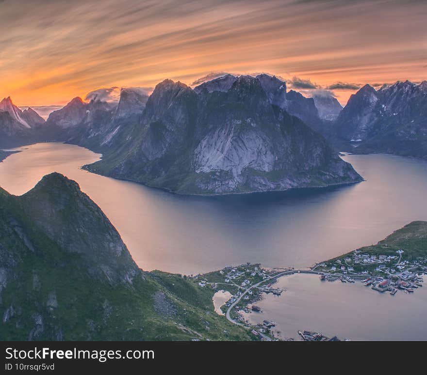 Stunning sunset from Reinebringen Norway. Nice view on Reine, Lofoten. Midnight sun is reflecting nicely on high clouds.