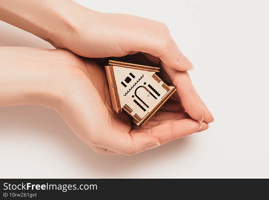 Hand holds house miniature model on white background. Investment  real estate  home  housing.