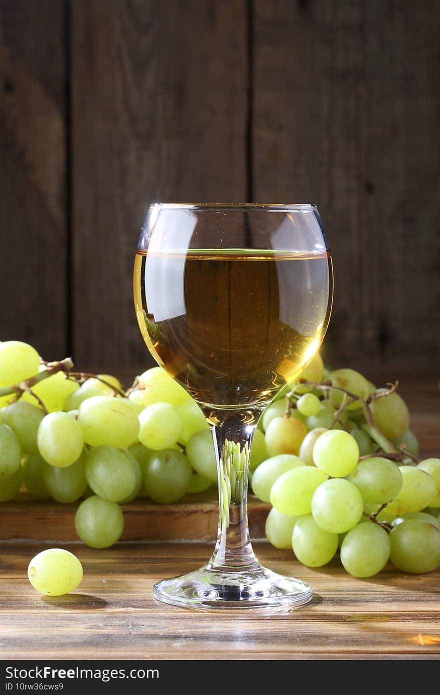 White wine with grapes on a wooden table