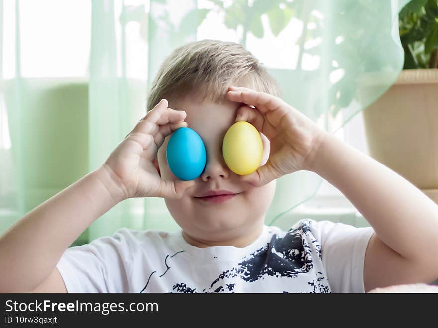 Portrait of a cute child with Easter eggs. Easter lunch. The feast of Holy Easter