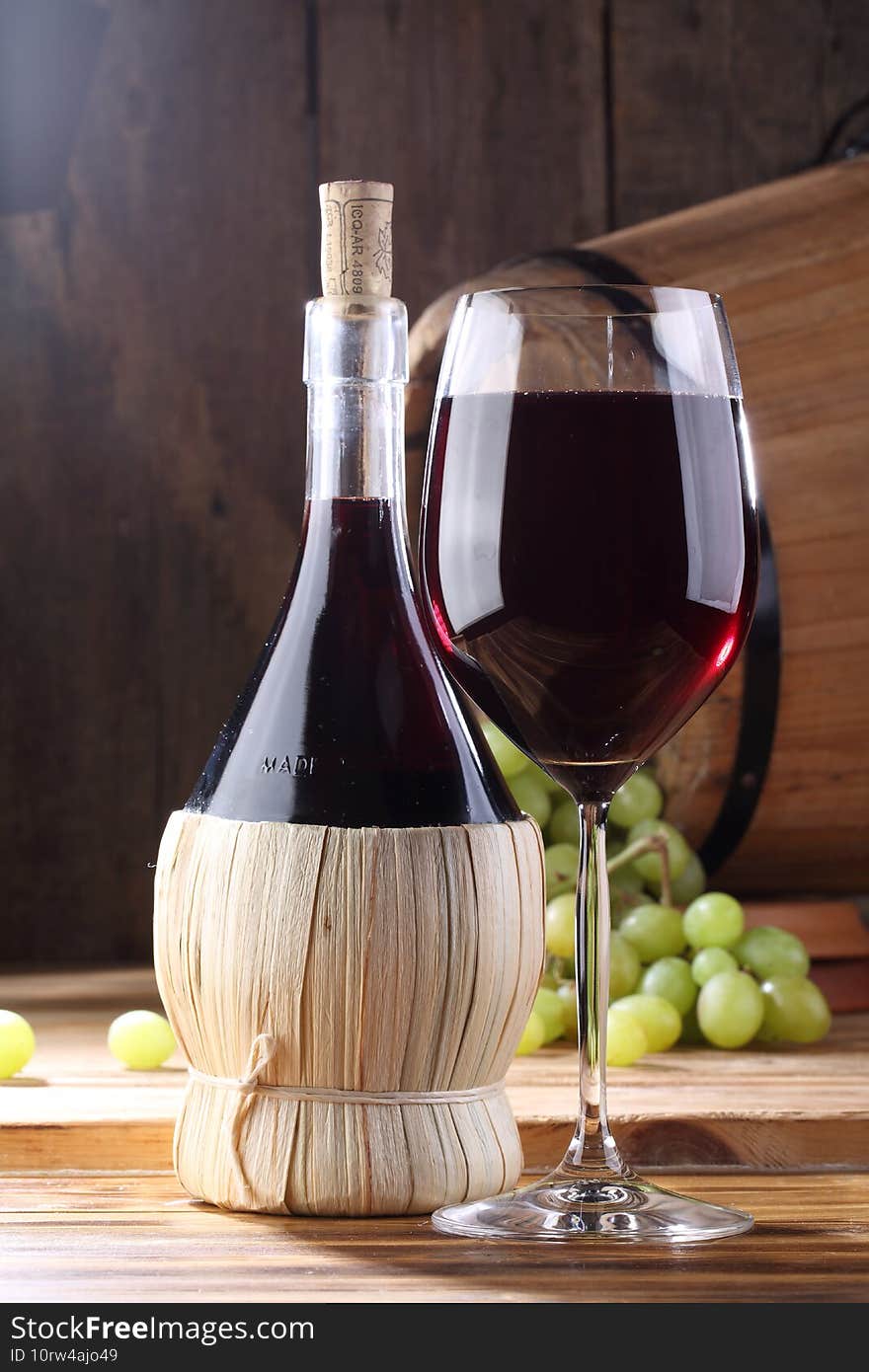 White wine with grapes on a wooden table. White wine in glass and bottle