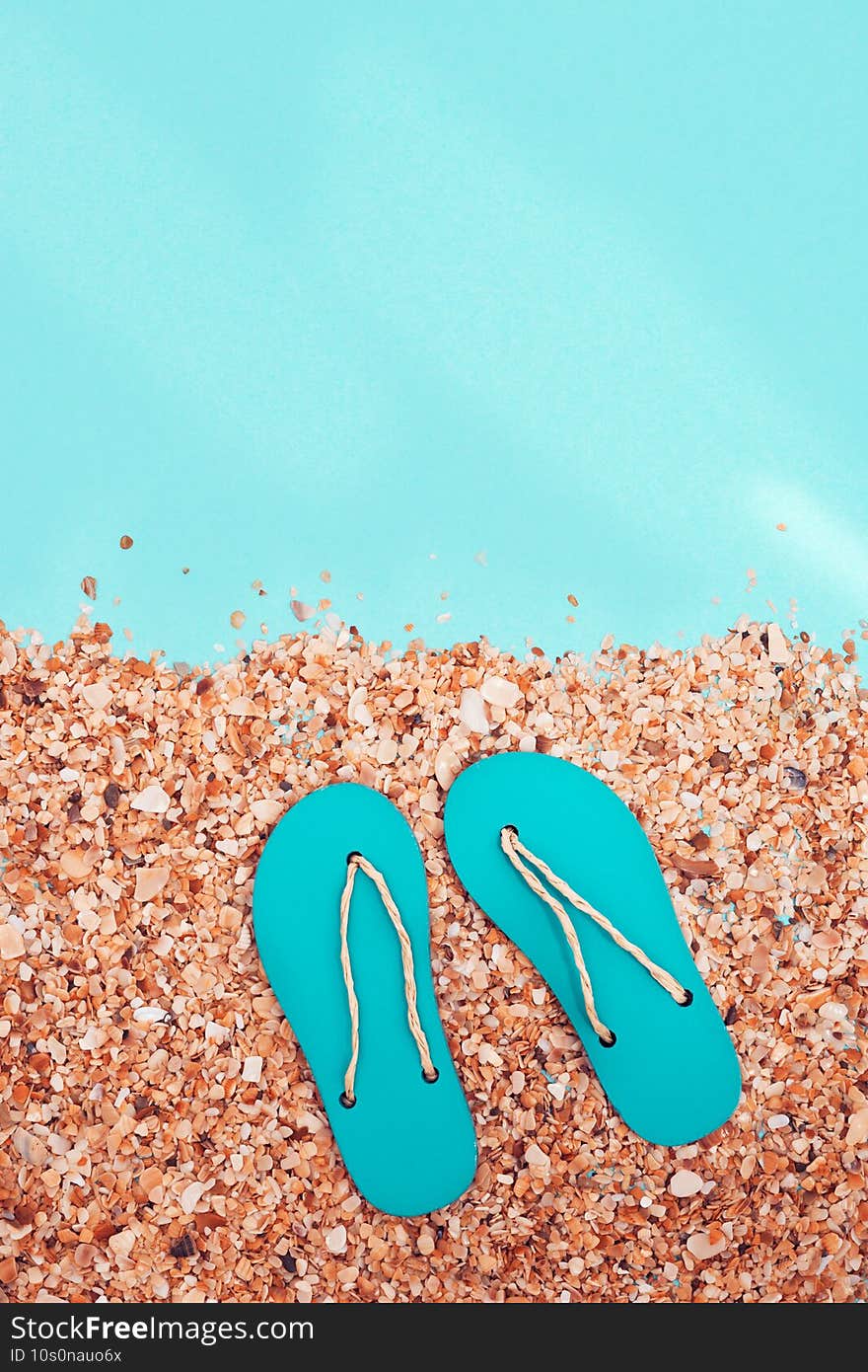 Concept of beach holiday. Sand Beach and and summer flip-flops with sunlight on abstract sea