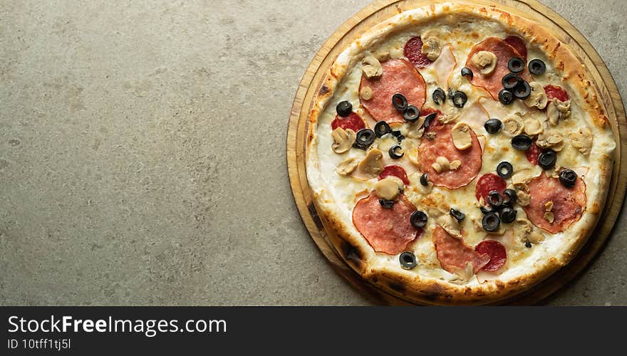 Italian pizza with olives  cheese and sausage on a gray background. Ready-made pastries in a pizzeria. Banner for the menu