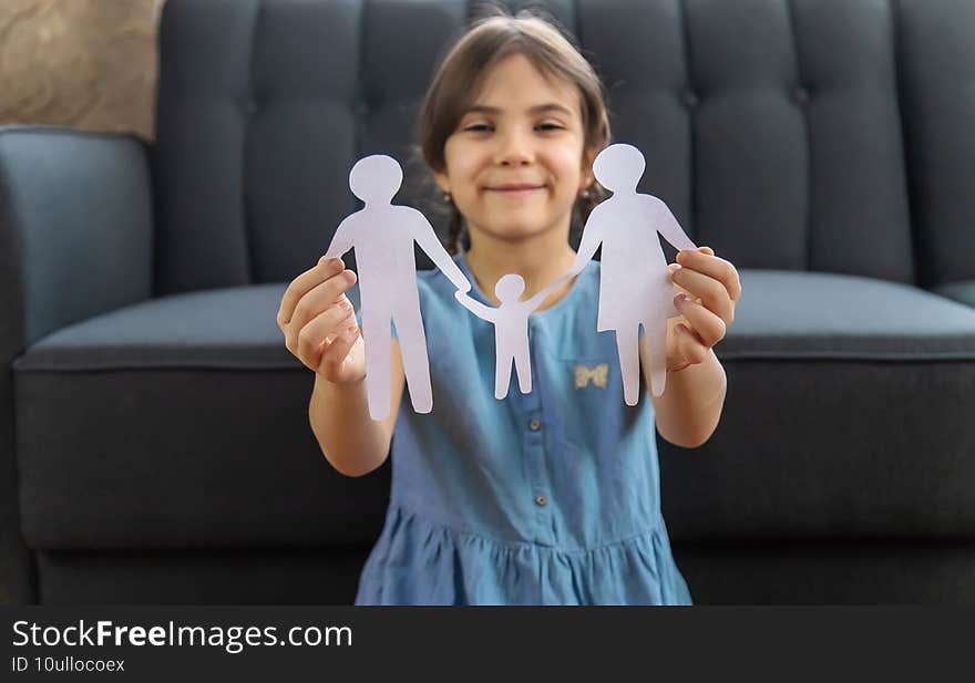 Child with a paper family in his hands. Selective focus. People.