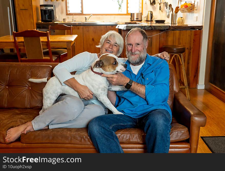 Couple relaxing at home and loving their pet. Positive image of life at home and New Normal