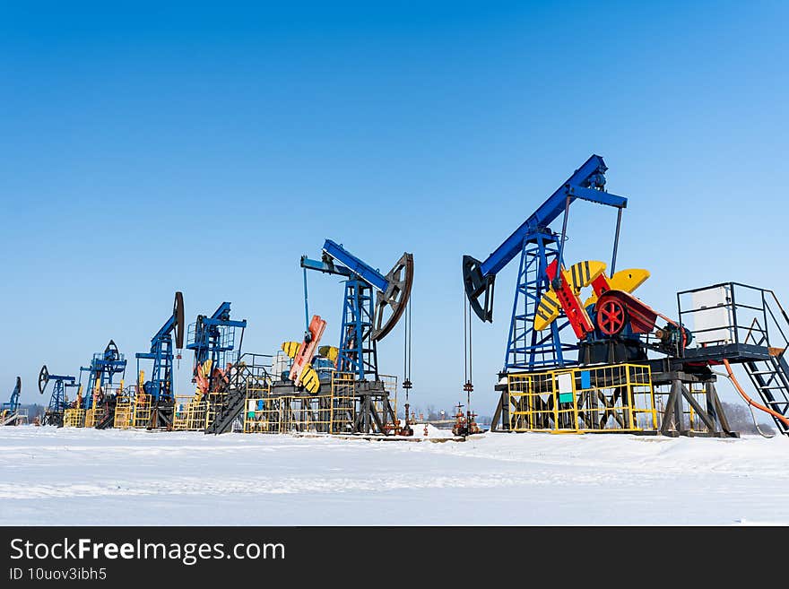 Oil and gas industry. Working oil pump jack on a oil field at winter sunny day. Oil production in Siberia.