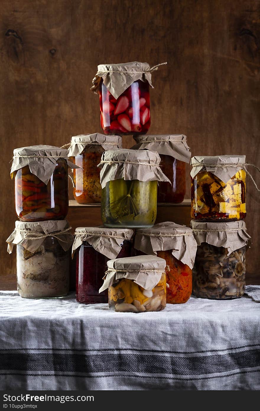 Many Jars with pickled vegetables and mushrooms