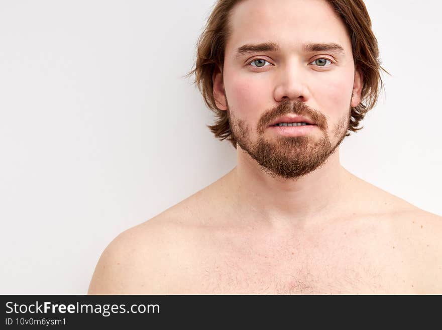 young caucasian shirtless male with long hair and beard posing at camera