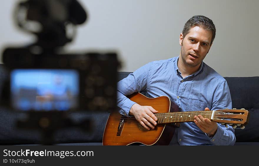 Man with spanish guitar in front of the video camera