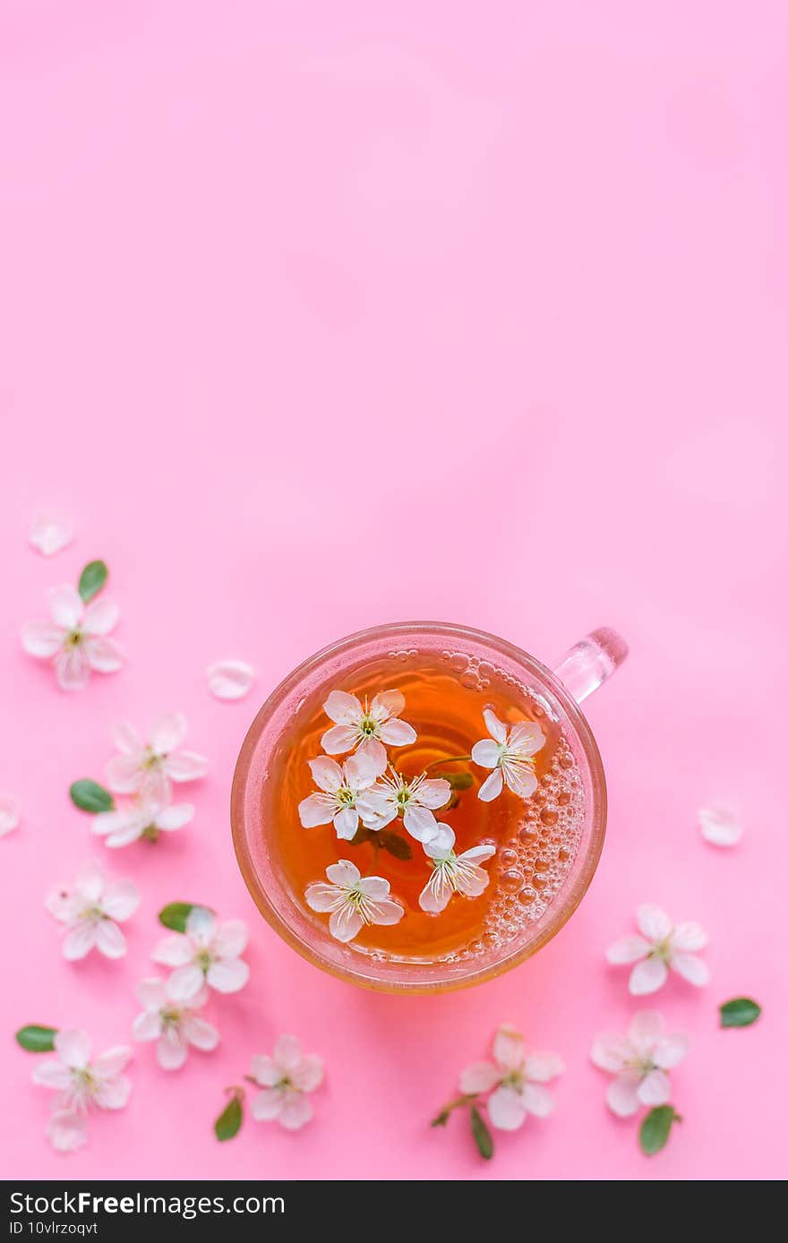 Cup of tea and spring apple blossom on a wooden background