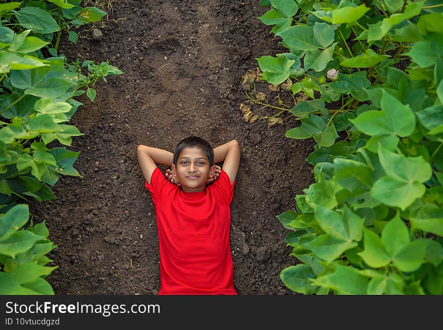 Smiling cute indian boy laying on ground