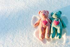 Two Small Teddy Bears Are Makes A Snow Angel On A Snow.Winter Sunny Evening.Copy Space Royalty Free Stock Images