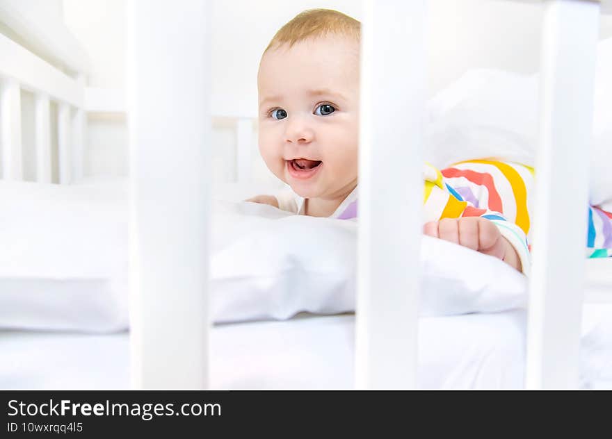 The baby in the crib goes to bed. Selective focus. People.