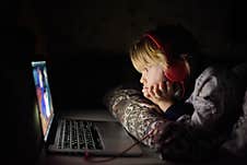 Cute Preschool Boy Wearing Headphones Is Watching Cartoon Movie By Laptop Before Sleeping In Bed Or Early In The Morning Right Royalty Free Stock Image