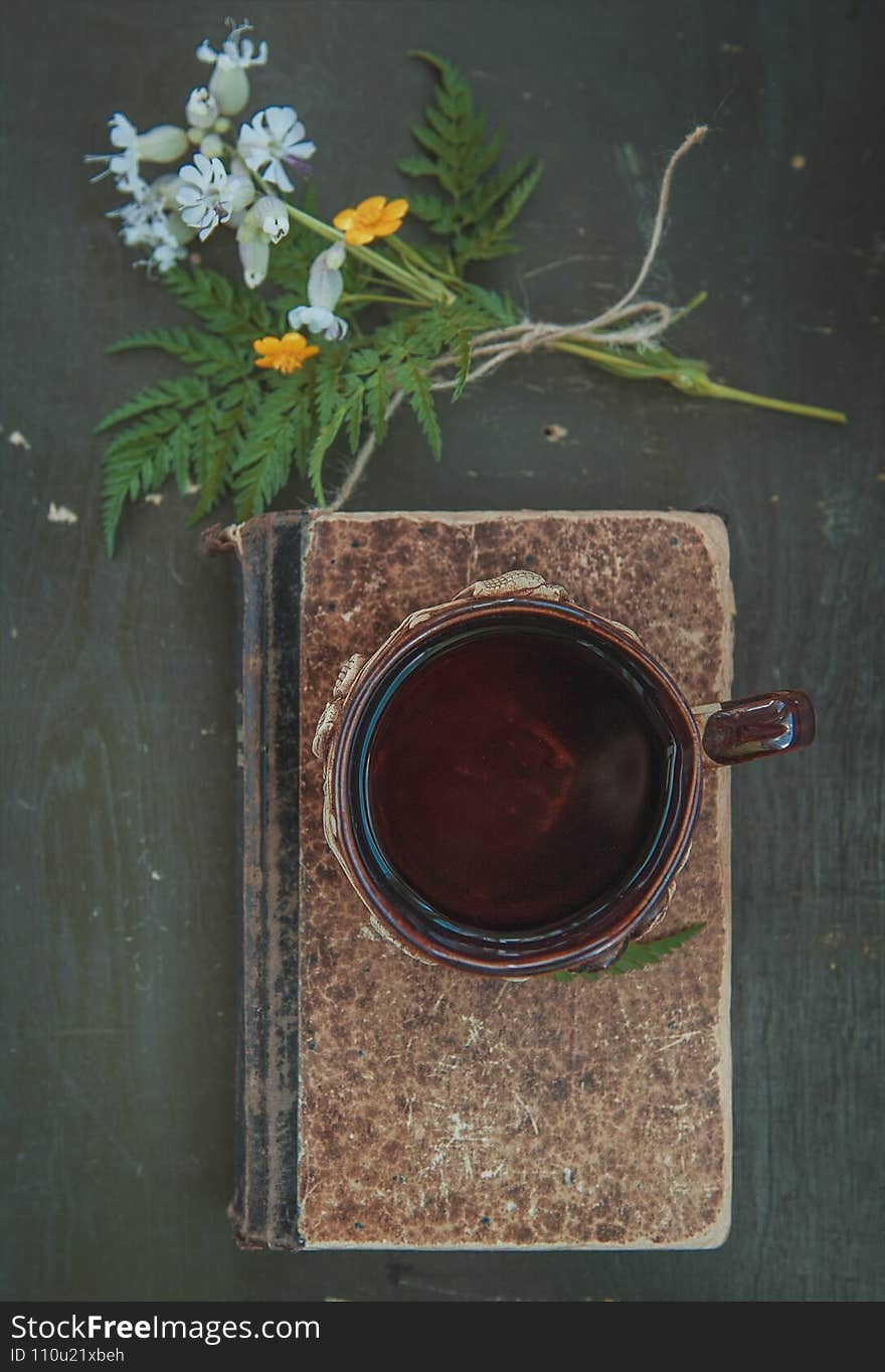 Cup of coffee with old vintage book on the table