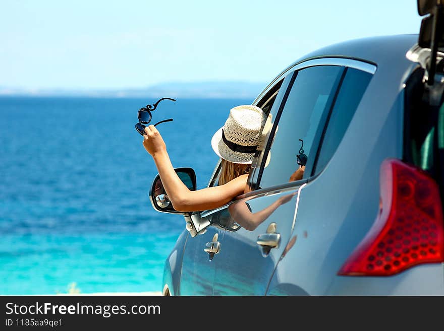 Happy driver girl in hat with sunglasses in car at sea in summer. Happy driver girl in hat with sunglasses in car at sea in summer