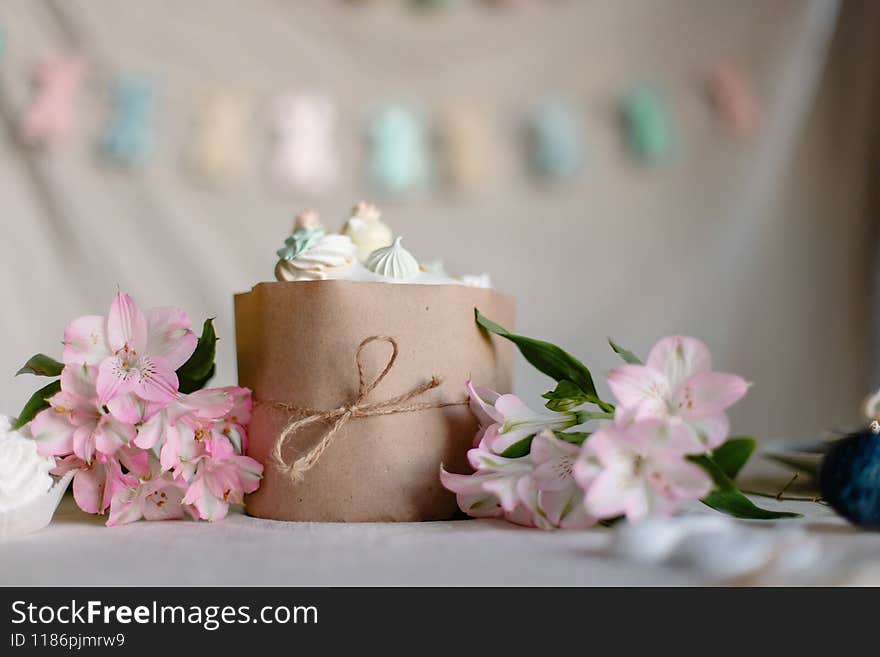 Cute beautiful Easter cake on a decorated table. Religious traditional Christian food. Orthodox Easter kulich with glaze and meringue. Still life.  homemade russian pastries. flowers background