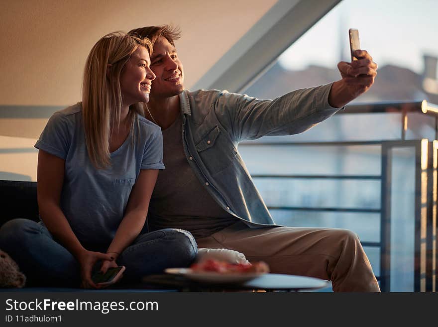 Caucasian couple taking selfie together at home