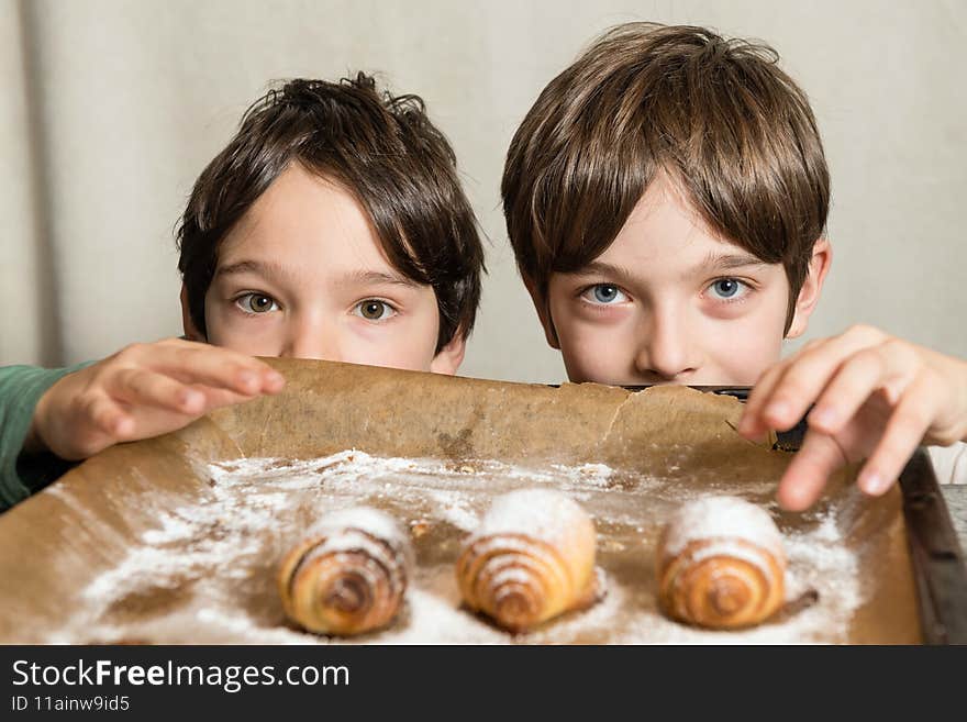Two kids reaching for freshly baked spiral cookies
