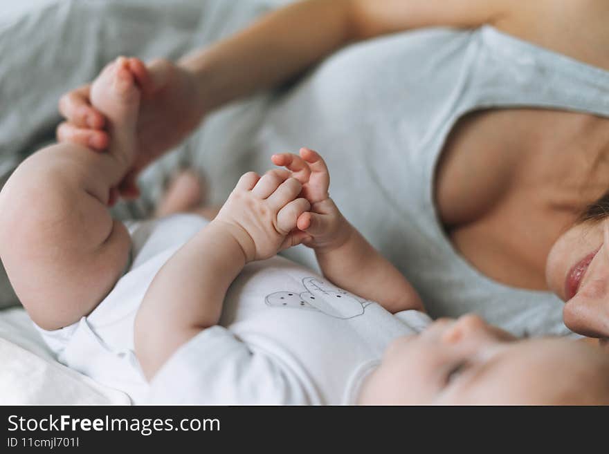 Young mother having fun with cute baby girl on bed, natural tones, love emotion. Young mother having fun with cute baby girl on bed, natural tones, love emotion