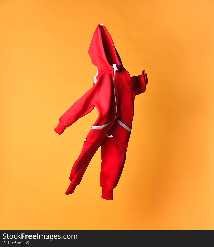 Fabric baby fleece red tracksuit, bodysuit with hood and zipper store assortment. Kids fashion garment sale. Textile clothing assortment. Shot on yellow table background. Fabric baby fleece red tracksuit, bodysuit with hood and zipper store assortment. Kids fashion garment sale. Textile clothing assortment. Shot on yellow table background