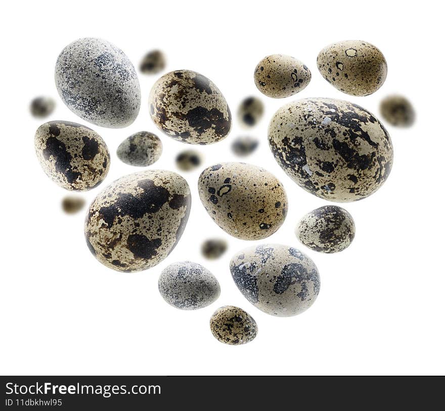 Quail eggs in in the shape of a heart on a white background.