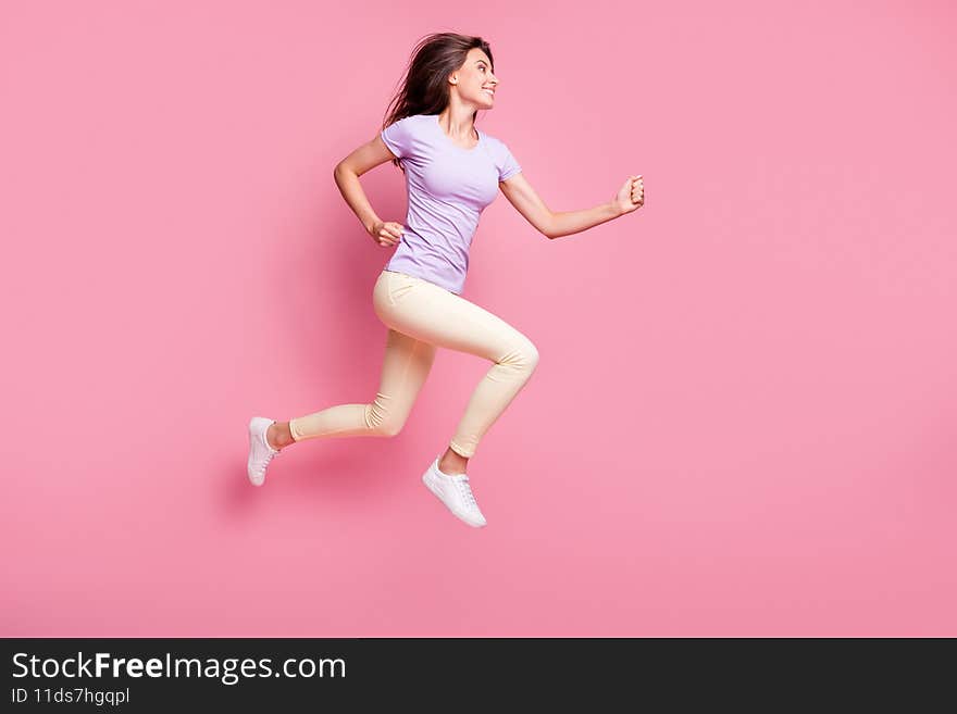 Full length body size profile side view of her she nice attractive glad cheerful cheery girl jumping, running jogging hobby leisure healthy life isolated over pink pastel color background. Full length body size profile side view of her she nice attractive glad cheerful cheery girl jumping, running jogging hobby leisure healthy life isolated over pink pastel color background