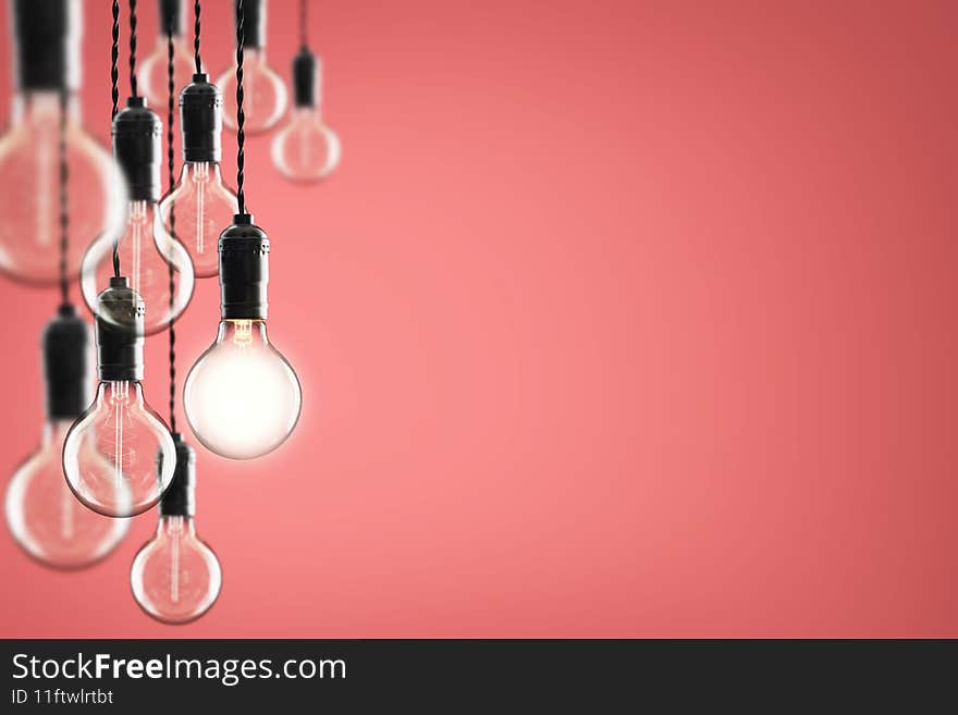 Idea and leadership concept - bulbs on the Living Coral color background