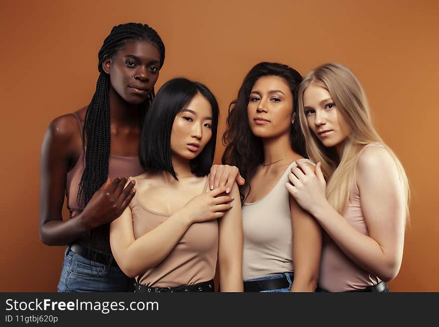 young pretty asian, caucasian, afro woman posing cheerful together on brown background, lifestyle diverse nationality