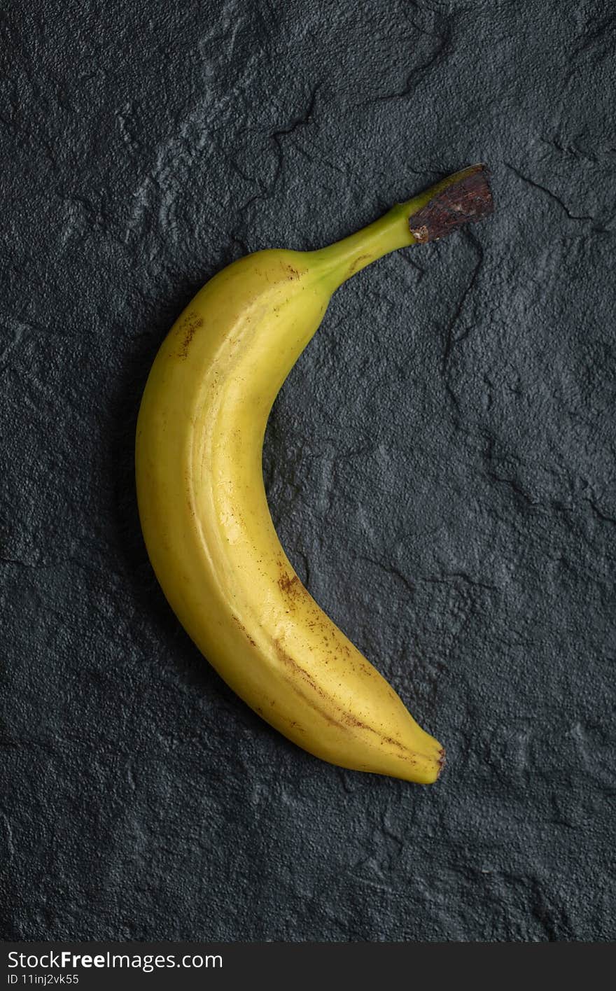 Vertical photo of fresh ripe banana over black background. High quality photo
