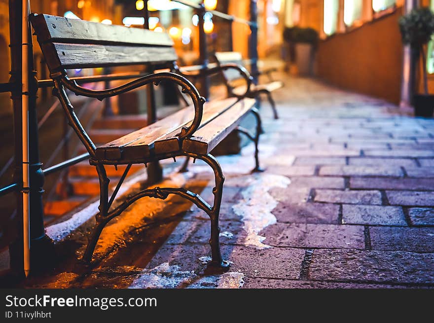 Wooden bench in the city space at night.