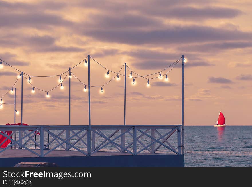 Romantic pier at sunset with lanterns