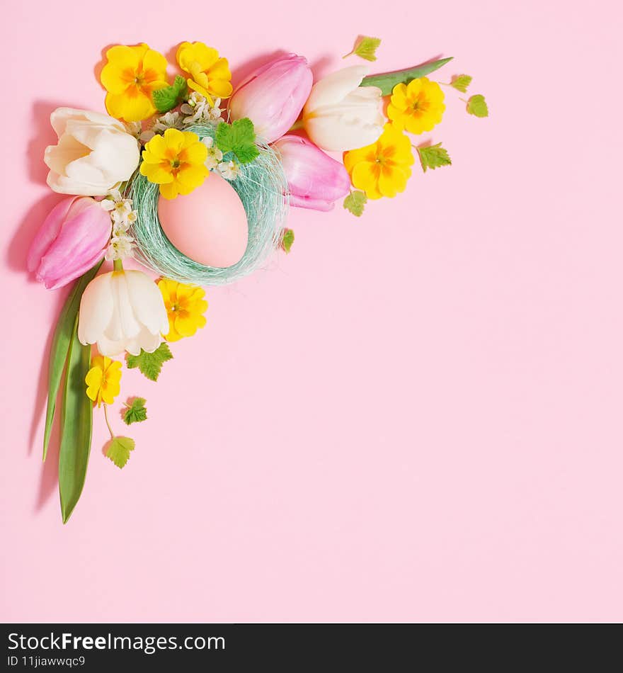 Easter eggs and spring flowers on pink background