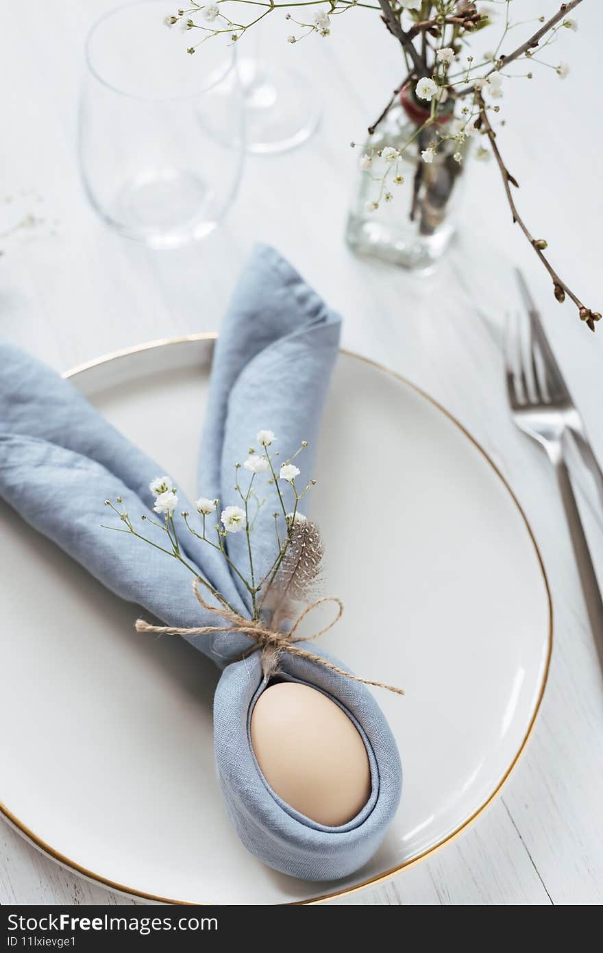 Easter table setting with egg in blue Easter Bunny napkin.