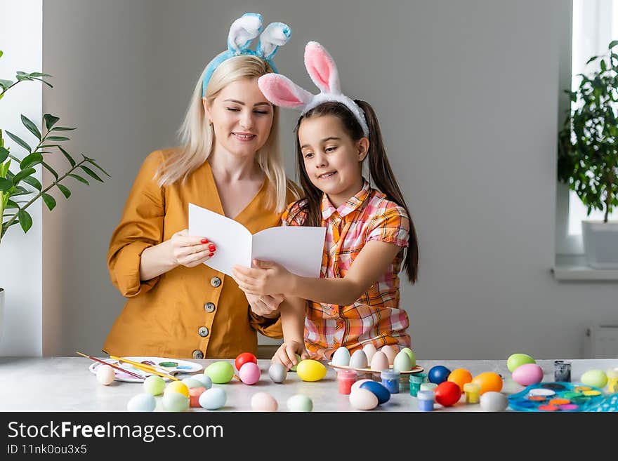 Mother and daughter together at home celebration concept sitting reading greeting card