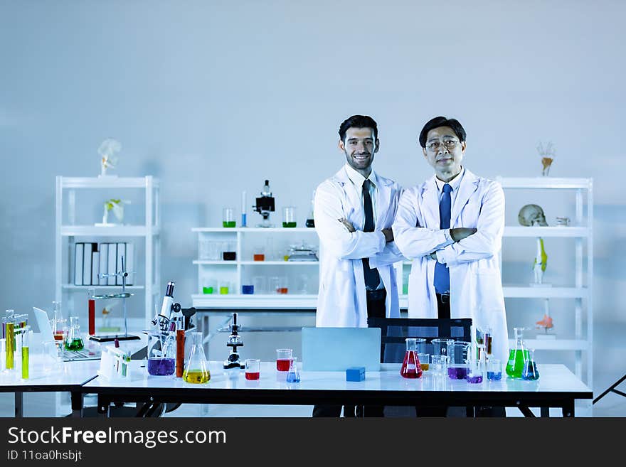Scientists In Laboratory. Medical workers at work. Portrait of caucasian and asian in modern scientific laboratory working together