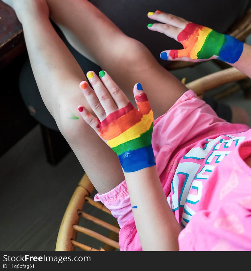 Child`s hand with painted colourful watercolour sitting in outdoor