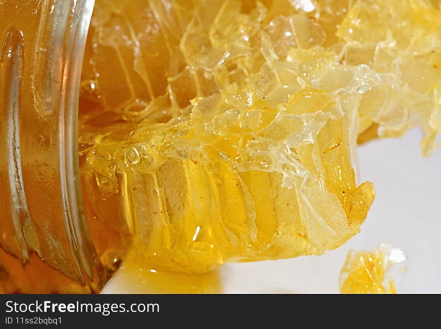 Close up of fresh honey from a honey comb in a jar.