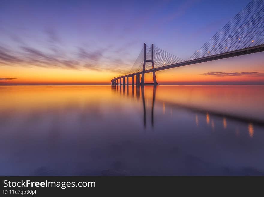 Sunrise on vasco da gama bridge one oh the longest supended bridges in europe. Sunrise on vasco da gama bridge one oh the longest supended bridges in europe