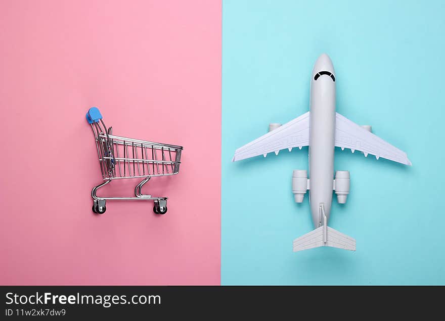 Flat lay composition. Cost calculation of Air delivery, shopping, logistics. Figurine of shopping trolley, airplane, calculator on blue background. Top view. Flat lay composition. Cost calculation of Air delivery, shopping, logistics. Figurine of shopping trolley, airplane, calculator on blue background. Top view