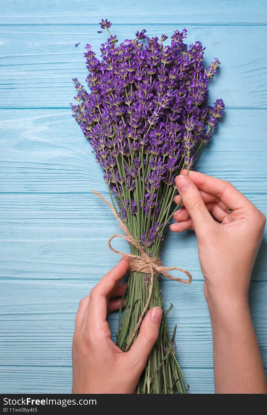 Lavender bouquet and girl hands on a blue background. Provence. Lavender bouquet and girl hands on a blue background. Provence