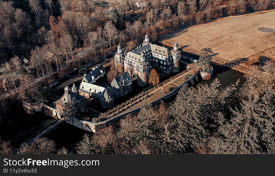 A top view shot of an old villa on the autumn forest