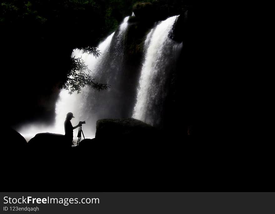 A photographer taking pictures of a waterfall at Khao Yai. A photographer taking pictures of a waterfall at Khao Yai.
