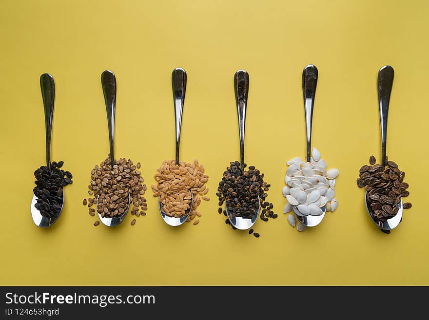 Watermelon, pumpkin and melon seeds on a yellow background.Different types of seeds,top view.Seeds background