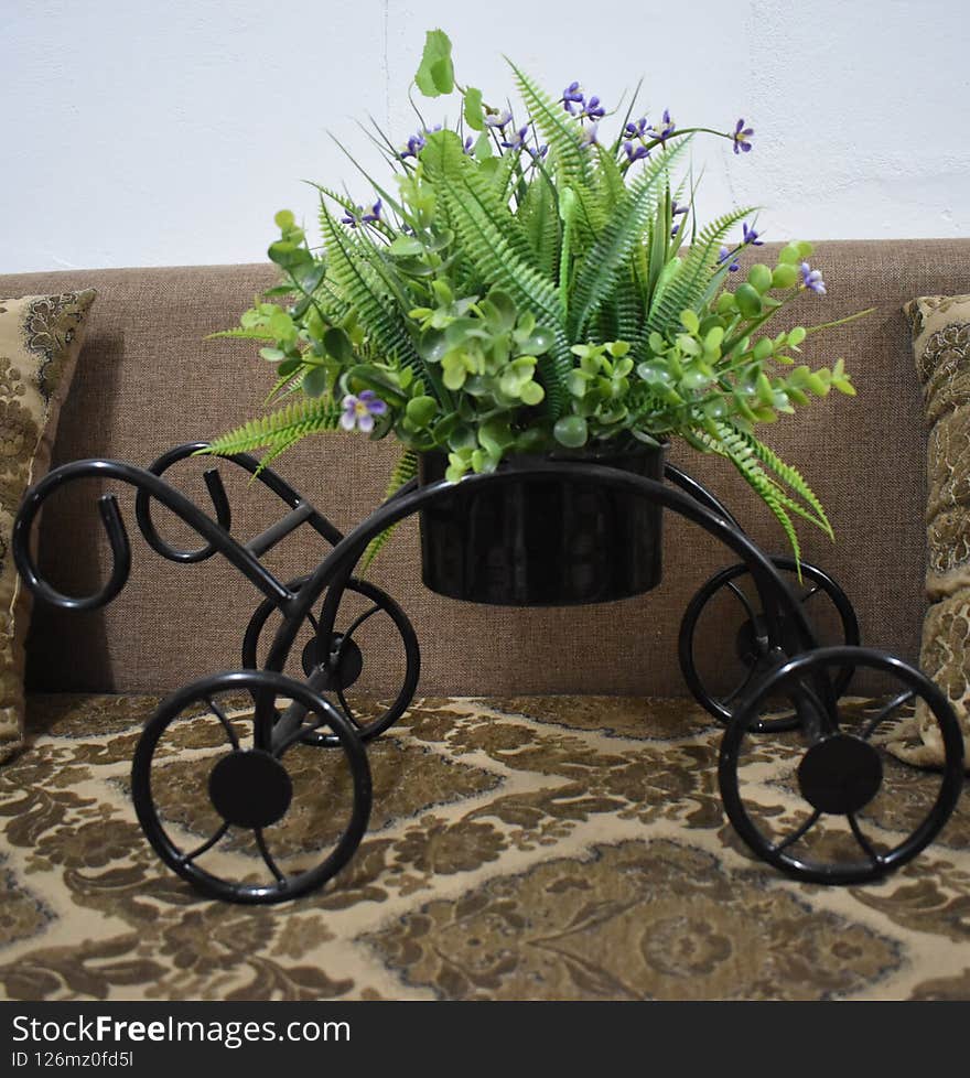 This is a beautiful cart with a vase having amazing green plant with purple flowers. This is a beautiful cart with a vase having amazing green plant with purple flowers.