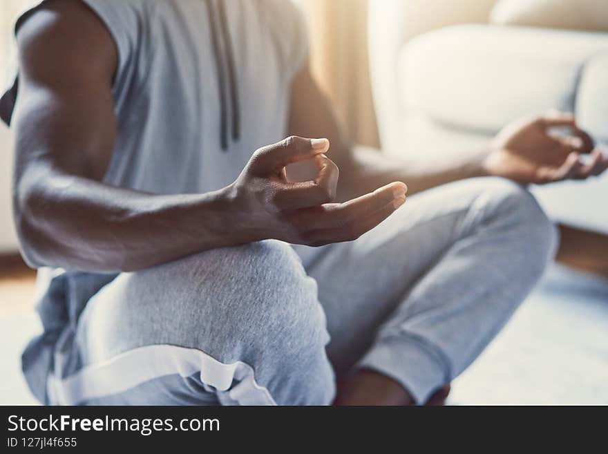 A young, strong and athletic African man in a seated siddhasana pose and mudra gesture. A young, strong and athletic African man in a seated siddhasana pose and mudra gesture