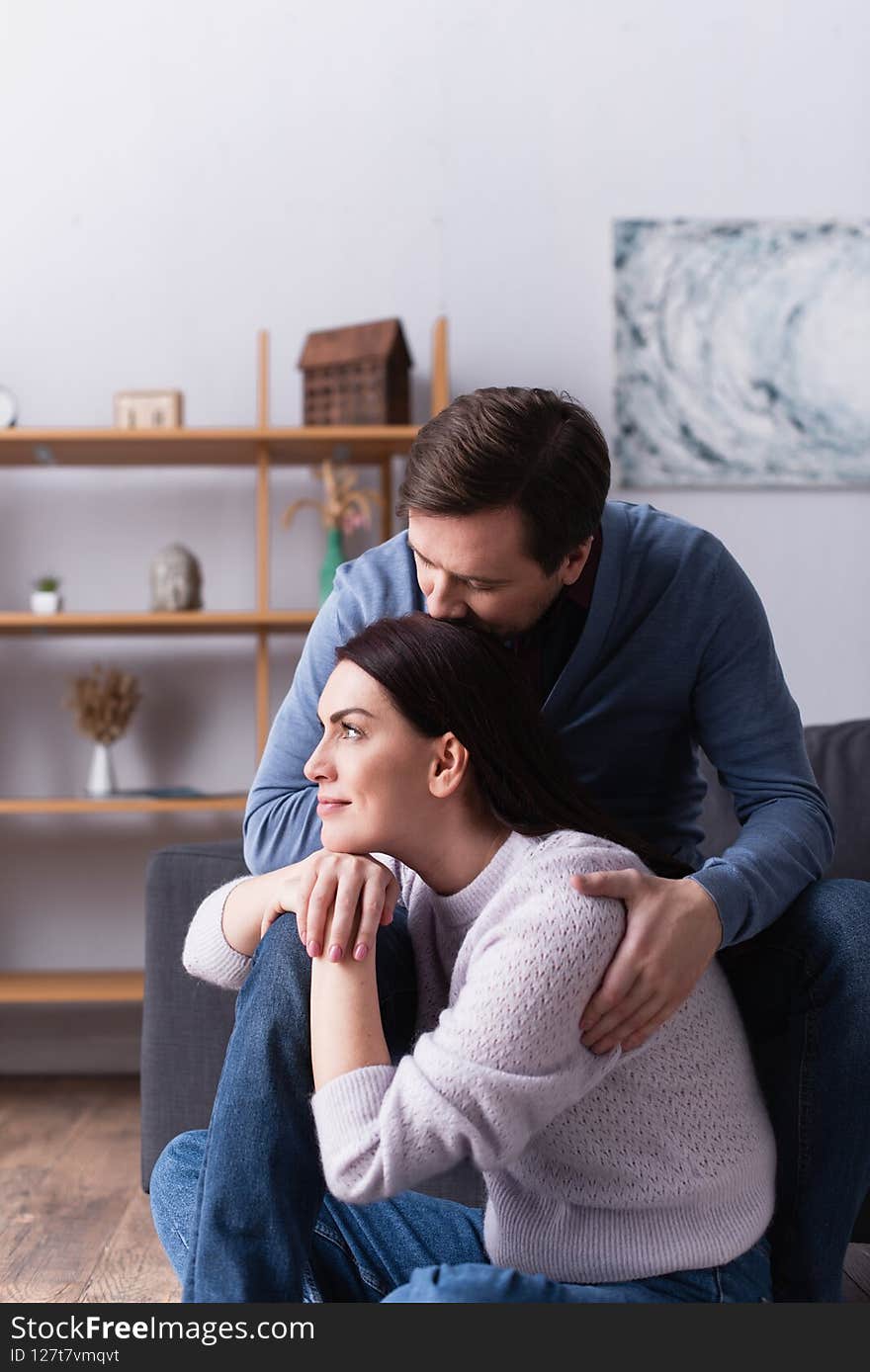 Woman sitting near husband on couch at home,stock image