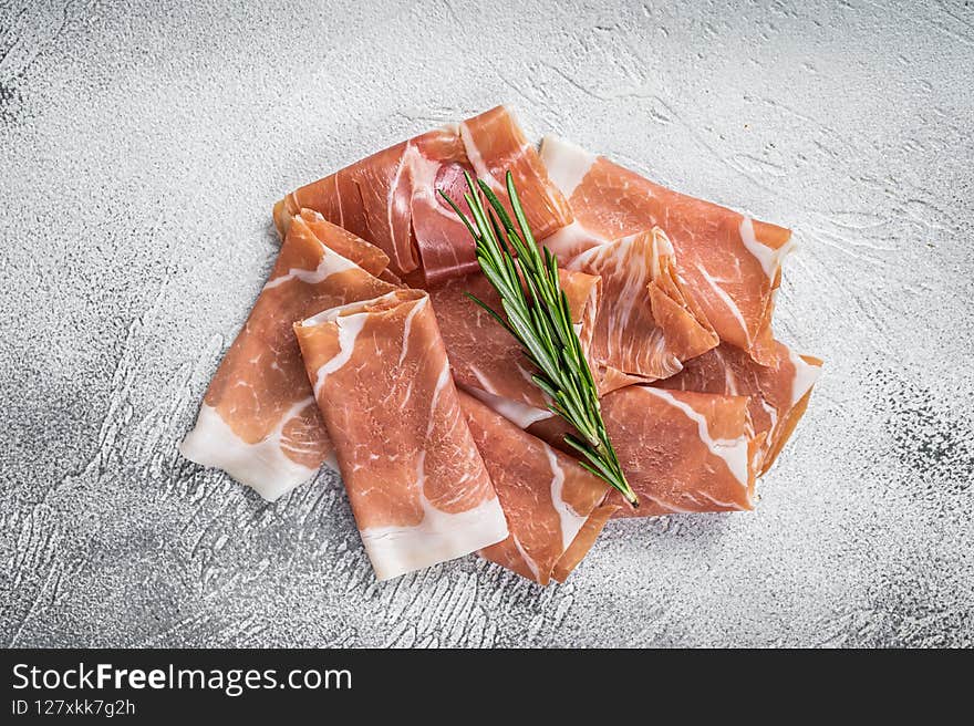 Italian prosciutto crudo parma ham on a table. White background. Top View.